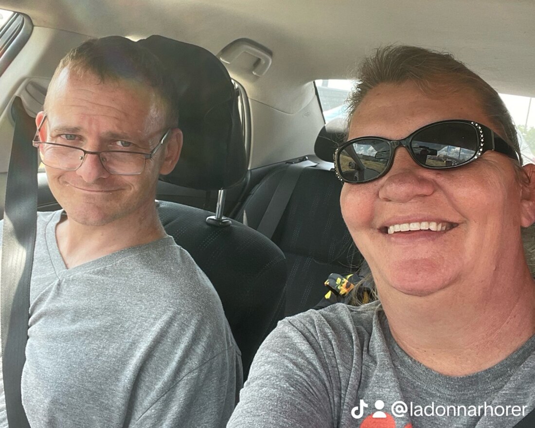 TJ Hoover, left, and his sister, Donna Rhorer. The picture is a selfie of two people in a car; they are both smiling.