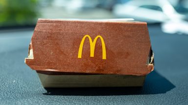 Close-up of packaging for a McDonald's burger with logo visible on the dashboard of a car, San Ramon, California, August 3, 2024. (Photo by Smith Collection/Gado/Getty Images)