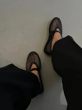 a detail image of the Alaia black Fishnet Flats