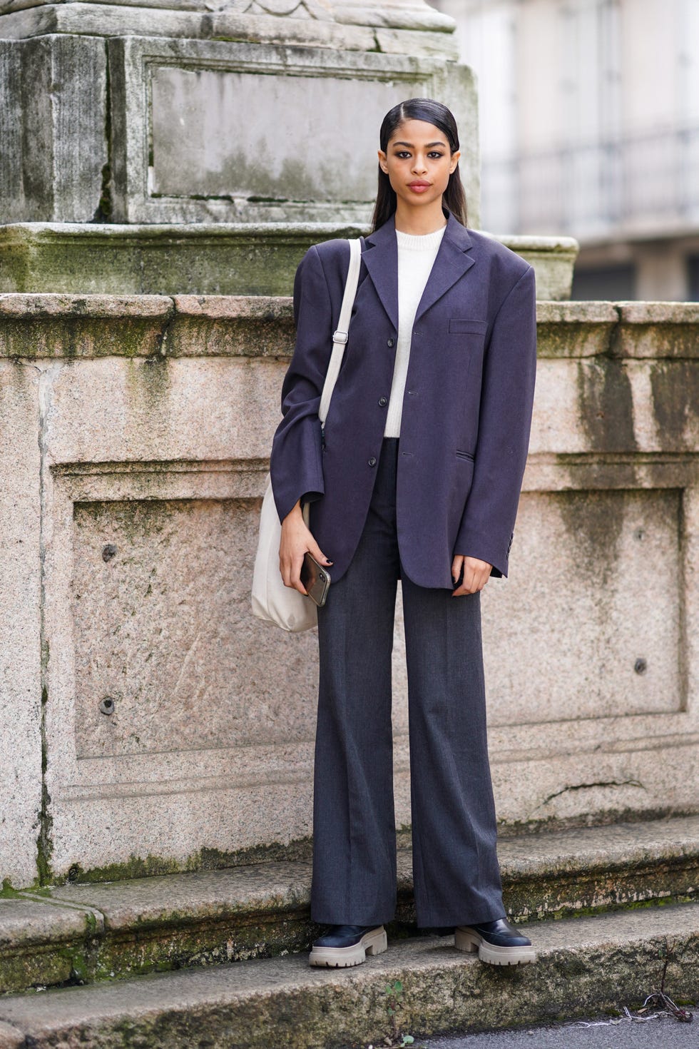 milan, italy february 20 a model wears a white t shirt, a gray oversized blazer jacket, a tote bag, suit flare pants, shoes, outside koche x pucci, during milan fashion week fallwinter 2020 2021 on february 20, 2020 in milan, italy photo by edward berthelotgetty images