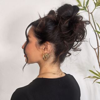 Woman with her hair styled in a messy bun.