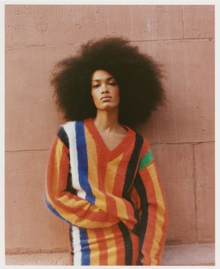 J.Crew model wearing striped colorful sweater and striped skirt