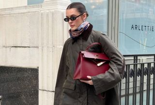 @sobalera wearing the Toteme Country Jacket with blue jeans, ankle boots, and a burgundy Hermes Kelly Bag in London